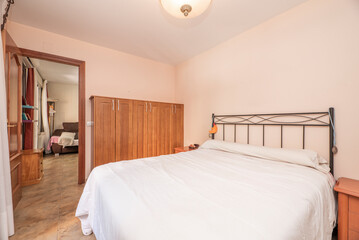 Bedroom with double bed with black metal headboard and marble floor