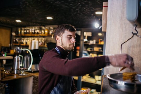 Confectioner decorating sweets in restaurant kitchen. Pastry chef making artisan author cakes. Cooking food concept.