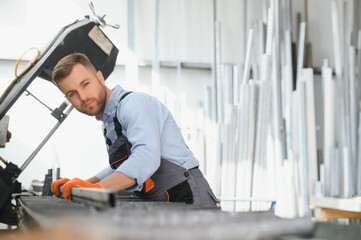 Factory for aluminum and PVC windows and doors production. Manual worker assembling PVC windows and...