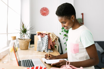 Young african entrepreneur woman working on workplace at office clothes store - Freelancer people...