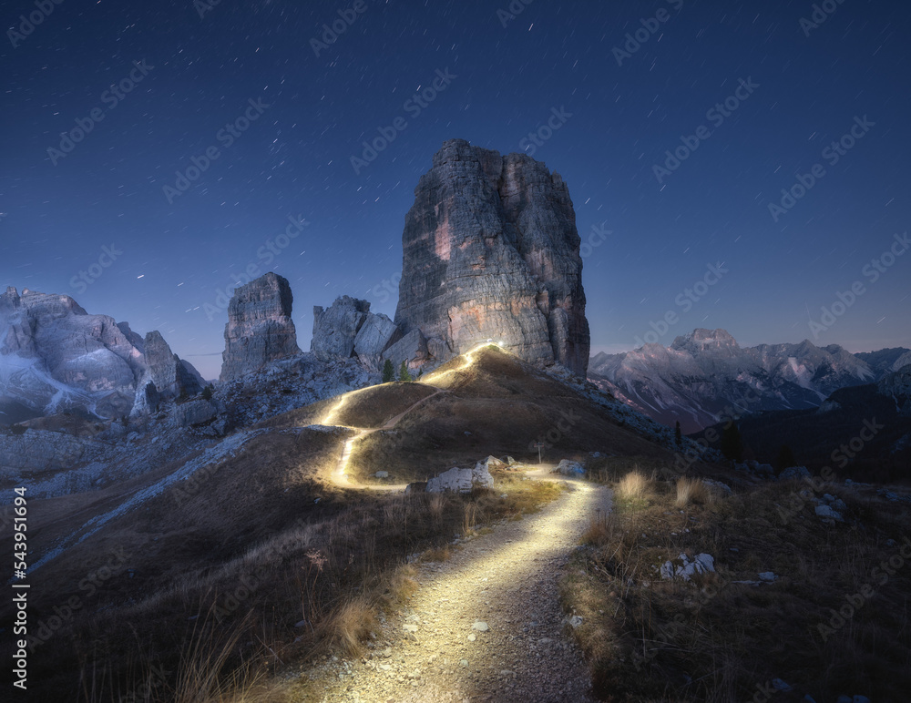 Wall mural flashlight trails on mountain path against high rocks at night in autumn. dolomites, italy. colorful