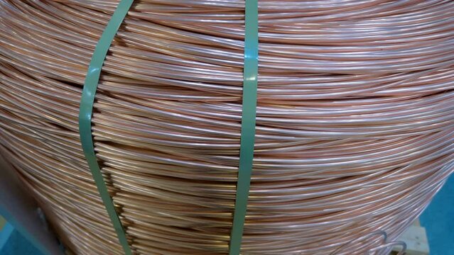Bundle of industrial single-core high power copper wires without insulator on a wooden pallet. Shot in motion. Macro. Closeup
