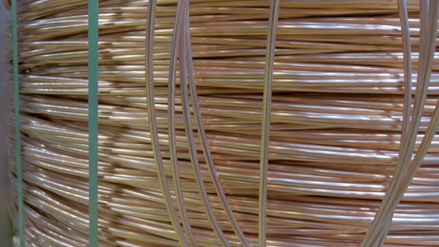 Bundle of industrial single-core high power copper wires without insulator on a wooden pallet. Shot in motion. Macro. Closeup