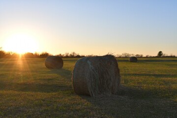 Sunset Over Hay Bales in a Farm Field