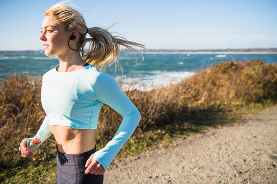 Young woman running on open air coastal trail run workout