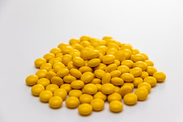 白いテーブルの上にたくさんの黄色の錠剤