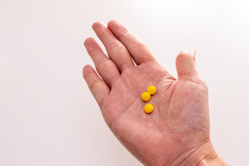 手のひらの上の黄色の錠剤