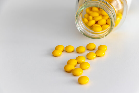 ガラス瓶からこぼれ出た黄色の錠剤
