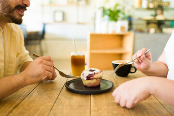 Close up of a smiling couple sharing dessert on a date
