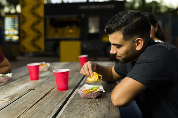 Hungry latin man eating mexican food from the food cart