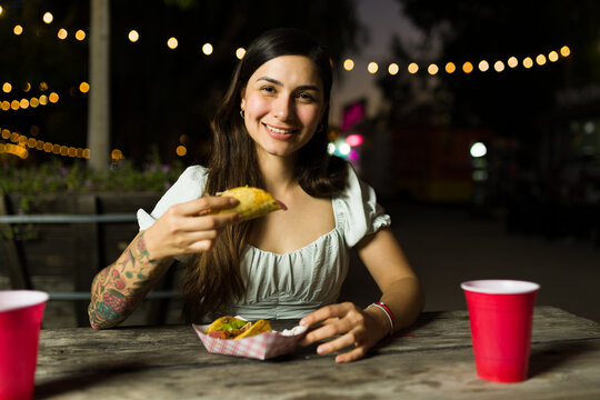 Latin young woman enjoying eating mexican street food