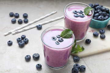 Freshly made blueberry smoothie on light grey table