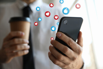 Young man using smartphone indoors, closeup. Social media