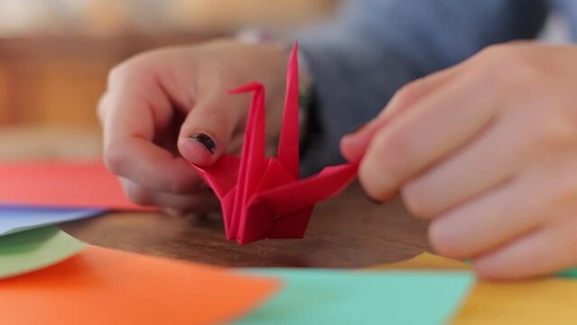 Close up of finished Origami crane. Japanese woman's hands. No face.