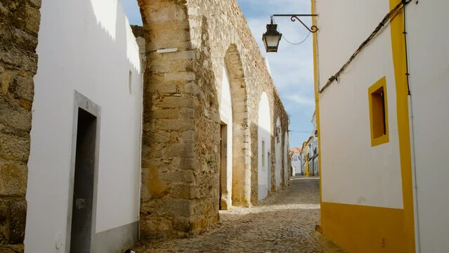 Discovering the narrow and picturesque streets of Evora, Portugal, featuring the famous whitewashed houses with yellow accents