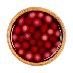 Homemade compote of blue grapes, in a wooden bowl. Blue grapes fresh from the garden, boiled with sugar to preserve it for winter. Close-up, from above, isolated on white background, macro food photo.