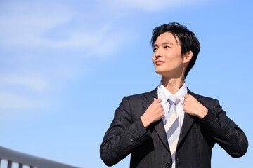 Profile of an Asian businessman adjusting his collar