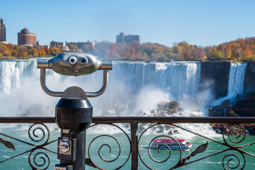 Coin operated binocular viewer telescope. American Falls in autumn foliage season. Niagara Falls...