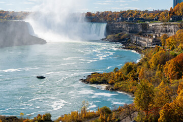Overlooking the Niagara Falls Horseshoe Falls in a sunny day in autumn foliage season. Niagara Falls City, Ontario, Canada.
