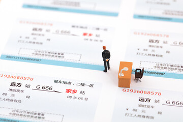 Fototapeta na wymiar Miniature creative office workers think about tickets for returning home during the Spring Festival