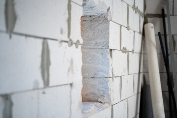 Hollowed out hole for a window in an aerated concrete brick wall. Planning and building a house of white large aerated concrete bricks