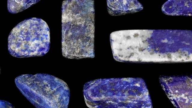 Lapis lazuli rare jewel stones texture on black background. Moving right seamless loop backdrop.