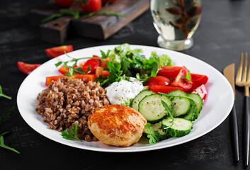 Fototapeta na wymiar Healthy dinner. Lunch bowl with buckwheat porridge, fried chicken cutlet and fresh vegetable salad.