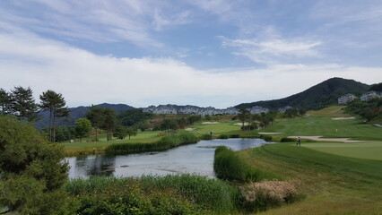 Fototapeta na wymiar Panorama view of golf course in Korea. Beautiful scenery with blue sky.
