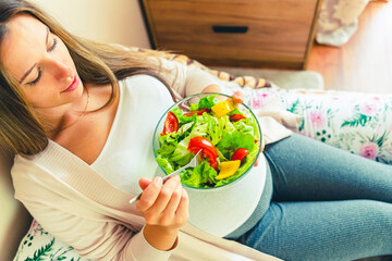 Pregnancy eating healthy salad. Happy pregnant woman eating nutrition food. People lifestyle food...