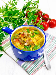 Soup with mung and noodles in blue bowl on board