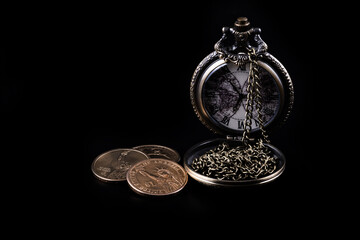 American money and vintage pocket watch on black background