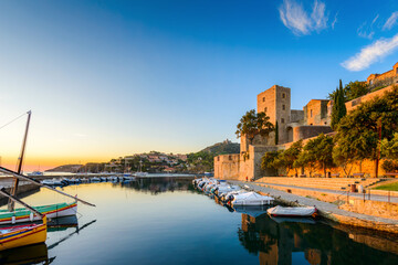 Medieval castle and boats at Collioure city at sunrise in France