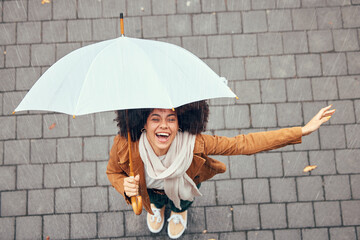 Black woman, umbrella and rain with smile, happy and enjoy weather in city being wet. Winter, young female and happiness for storm, cheerful and joyful with cover, comfortable and rainy outdoor. - obrazy, fototapety, plakaty
