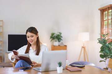 Relaxing time concept, Women reading holy bible after working with laptop at modern home office