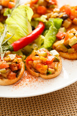 bruschetta with vegetables on white plate