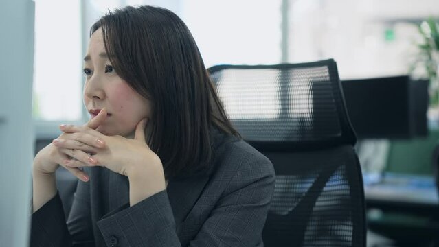 みんなでパソコン画面を見る会社員グループ