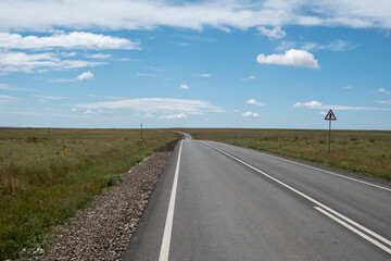 Fototapeta premium Direct asphalt road. Farm fields along the route. Sunny day. Summer