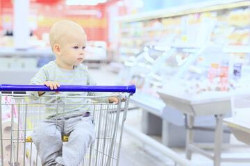 kid in the store on the grocery cart is a small customer