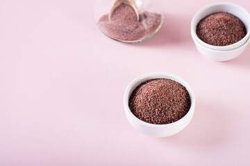 Black Himalayan rock salt kala namak in bowl on pink background