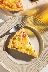 Piece of freshly baked quiche with salmon and broccoli
