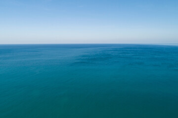 Aerial view of a blue sea surface water texture background and sun reflections Aerial flying drone...