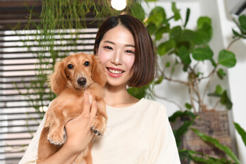 ペットの犬（ダックスフンド）と若い女性