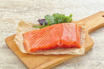 Raw salmon fillet over board
