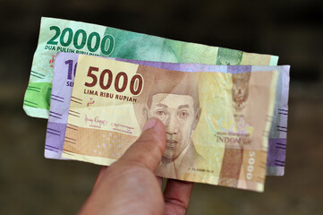 Hold Indonesia rupiah banknote money for trade transaction