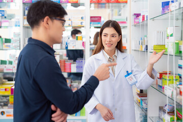 Asian pharmacist woman explain how to use a drug and medicine to her customer