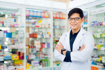 Asian pharmacist man in pharmacy store - 544004236