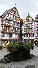 Architecture in Bernkastel on the Moselle in Rhineland-Palatinate, Germany. fountain with flowers