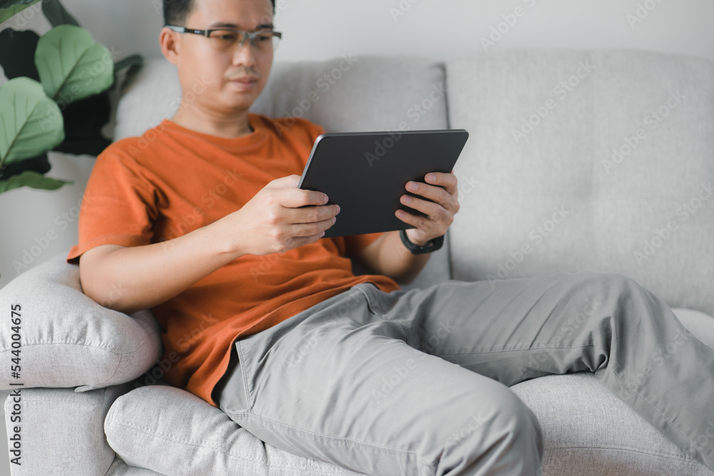 Poster Man using a smart tablet to browse the internet, view content on social media, communicate remotely, and select items to purchase from an online store.