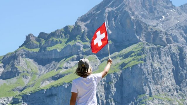 Young boy with Switzerland flag and alps mountain background