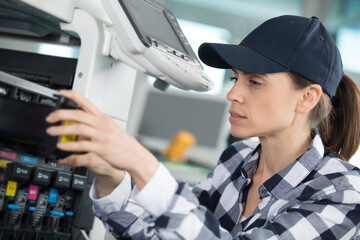 woman checking the ink levels on a professional printer
